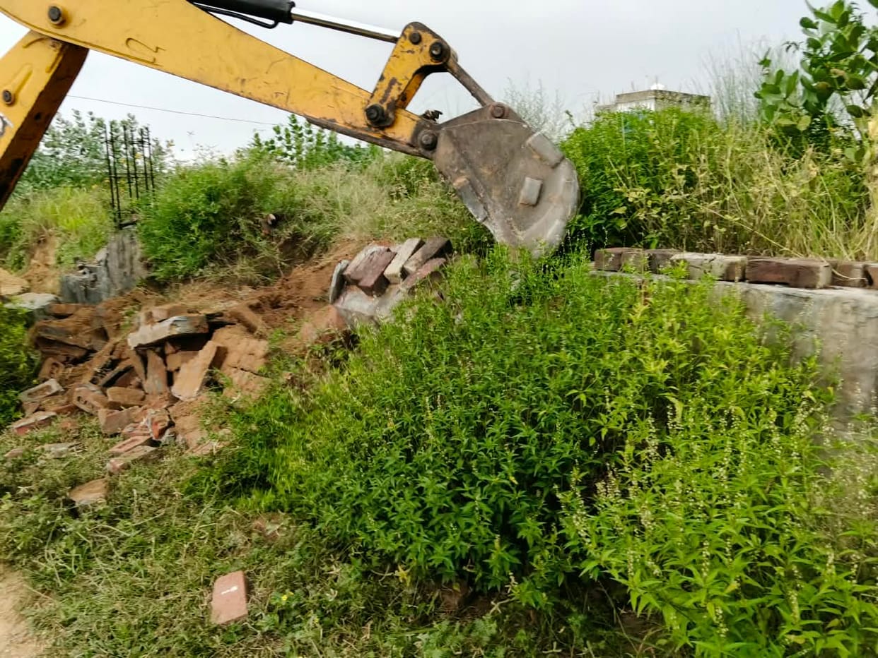 Bulldozer action against illegal colony; six DPC structures and three boundary walls demolished across two acres.