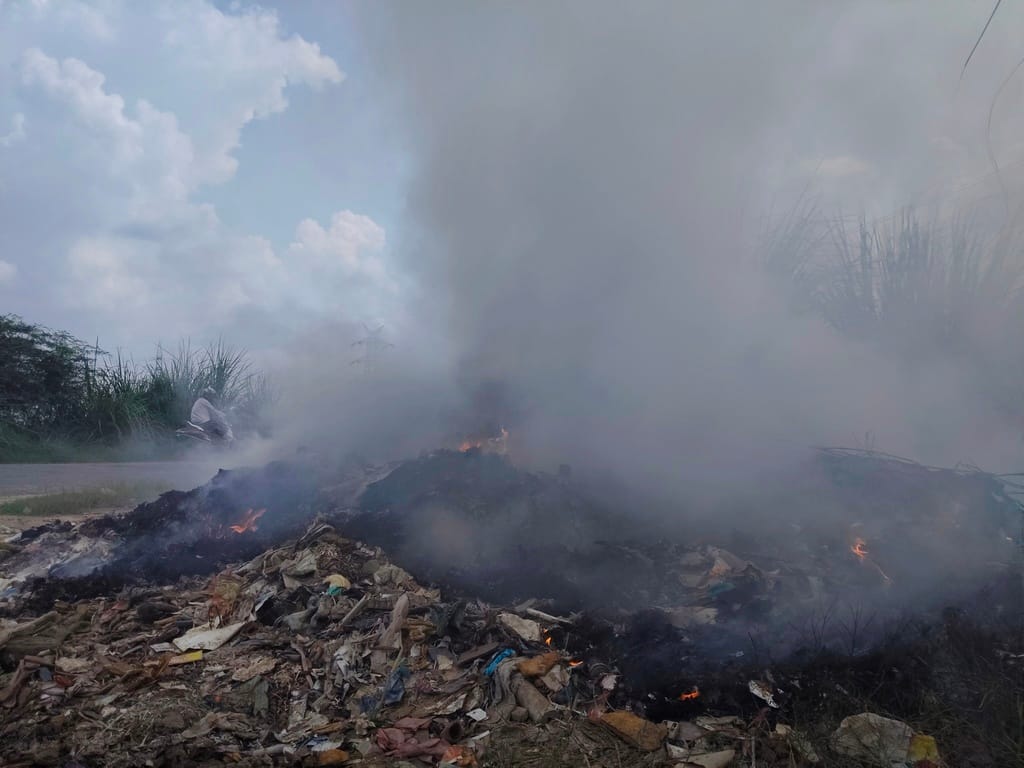 Open burning of garbage troubles passersby; poses pollution risk.