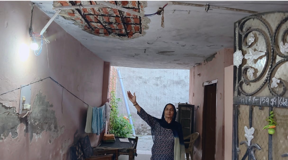 महिला घर की छत को दिखाते हुए। स्वयं