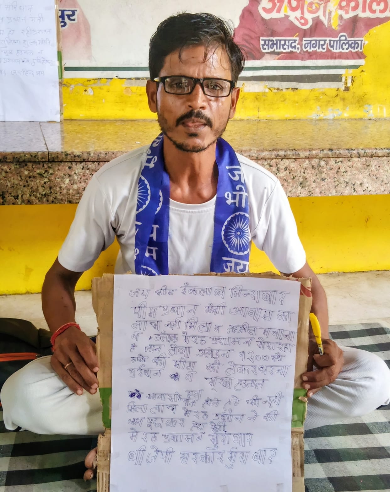 Did not receive benefits of PM Awas Yojana; sits on a protest.