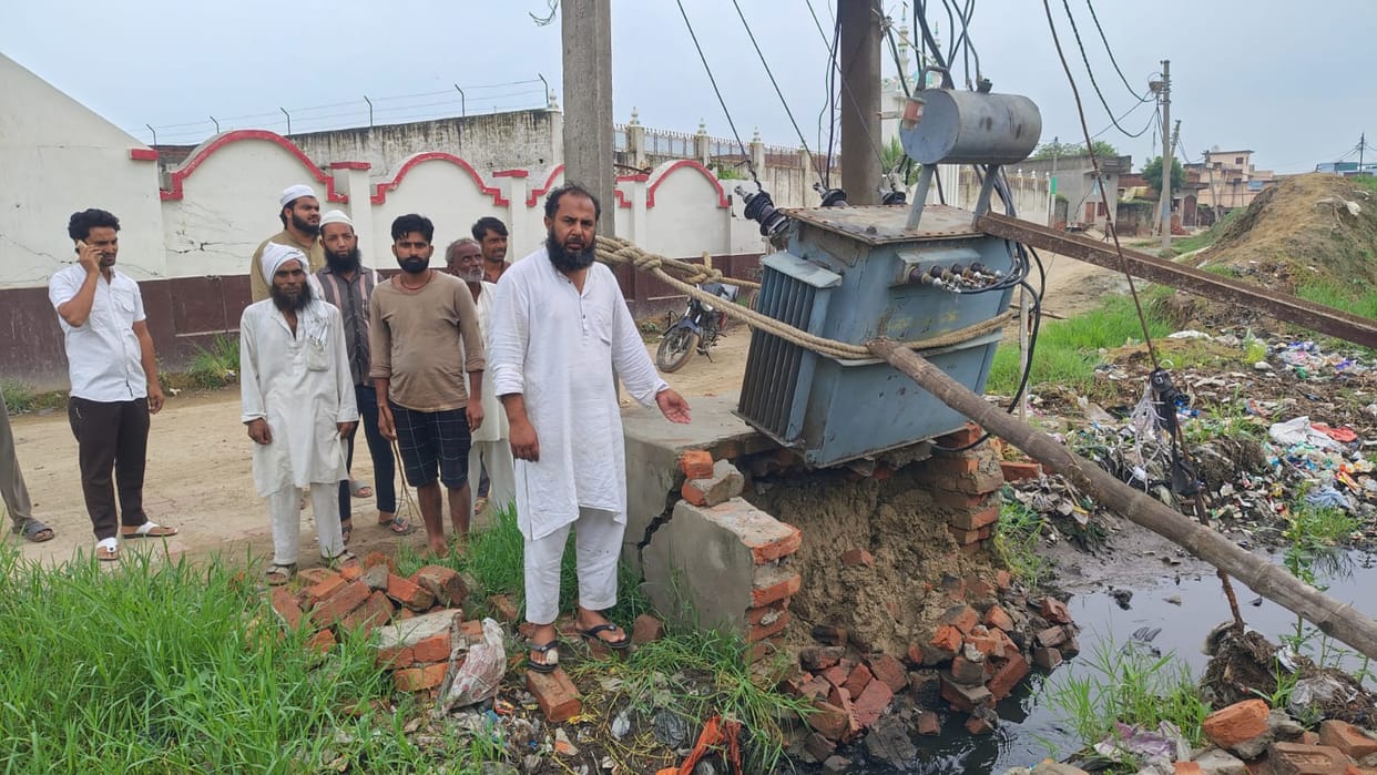 Transformer on the verge of collapse; villagers keeping it propped up with wooden supports.