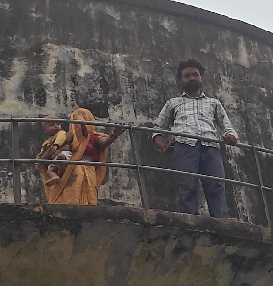 Man climbs water tank with wife and innocent child amidst property dispute.