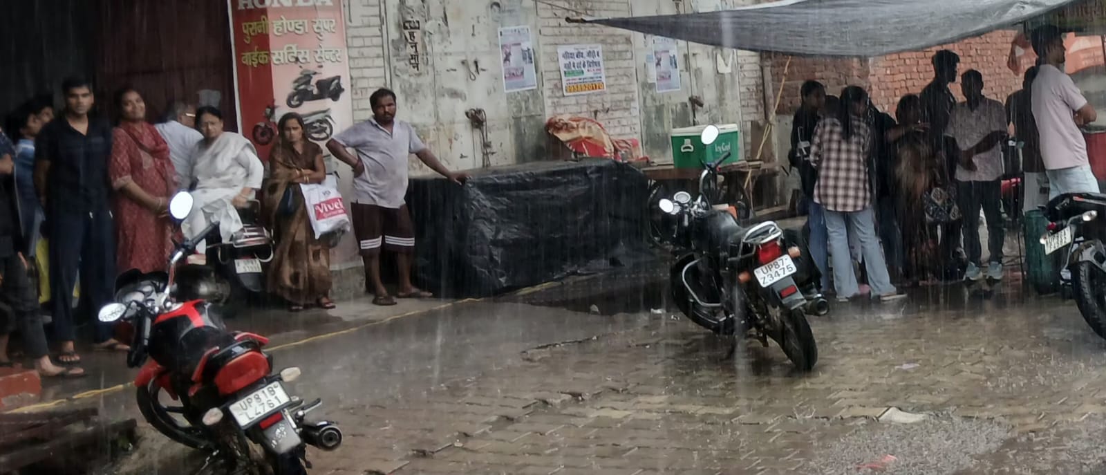 फोटो 05 कासगंज में बारिश के दौरान सुरक्षित जगह खडे लोग। स्रोत: संवाद