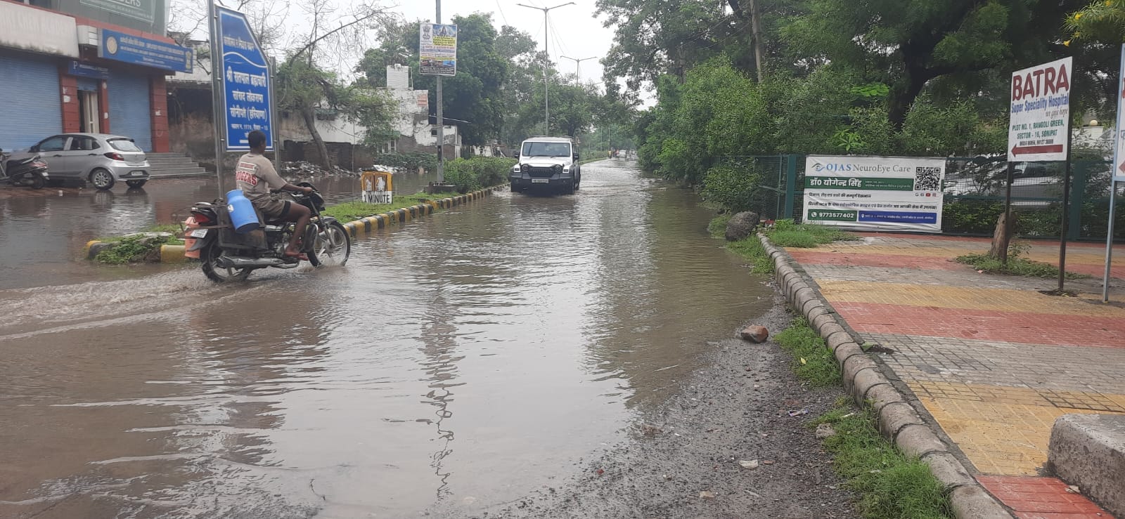 फोटो : सोनीपत के सेक्टर-15 में सड़क पर भरे बारिश के पानी से गुजरते वाहन। संवाद