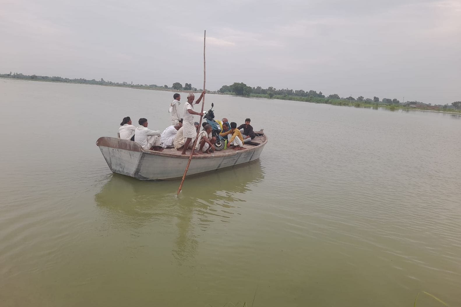 फोटो41सनौढ़ी पुल के पास भरे बाढ़ के पानी के बीच से लोगों को नाव में बैठाकर ले जाते नाविक पेशक