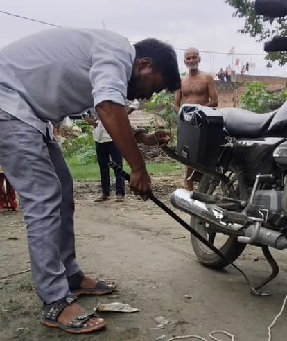 पलिया खुर्द में बाइक  में फंसे सांप का रेस्क्यू करते रामगोविन्द। संवाद