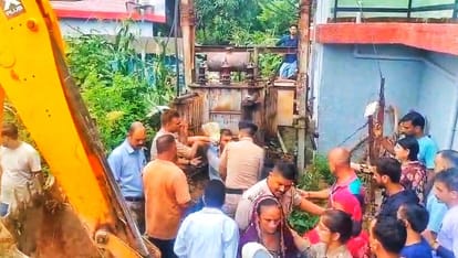 देहरा की दियाल पंचायत में ट्रांसफार्मर के सामने बैठे व्यक्ति को हटाती पुलिस। मौके पर एकत्रित ग्