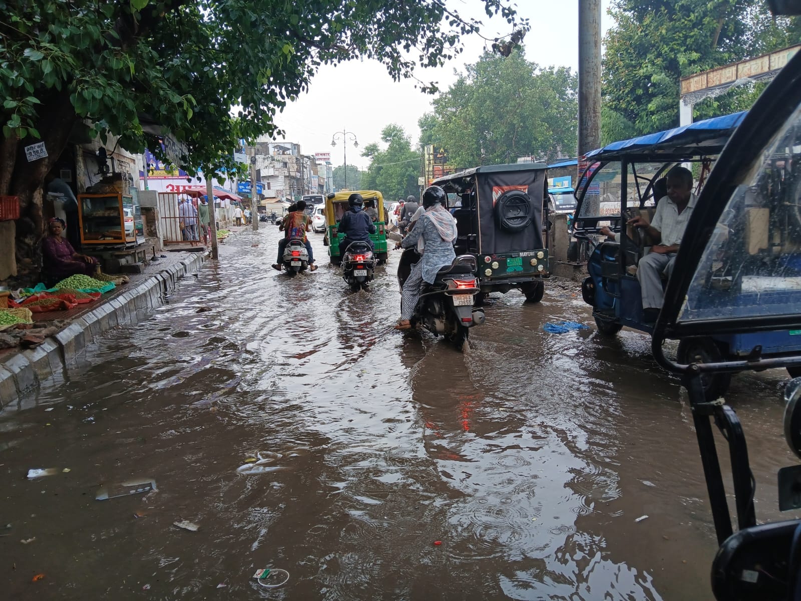 बारिश के बाद सड़क पर हुआ जलभराव, पानी के बीच से गुजरते वाहन चालक।संवाद