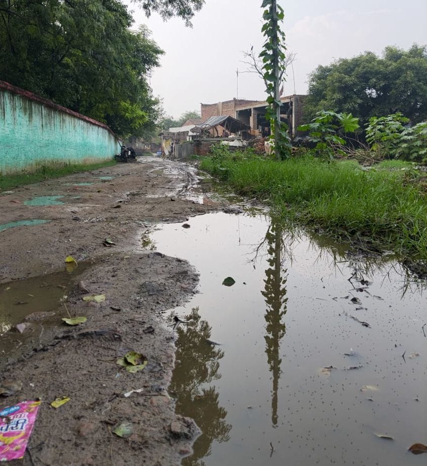 Children forced to use a muddy path to get to school; demand for a paved road.