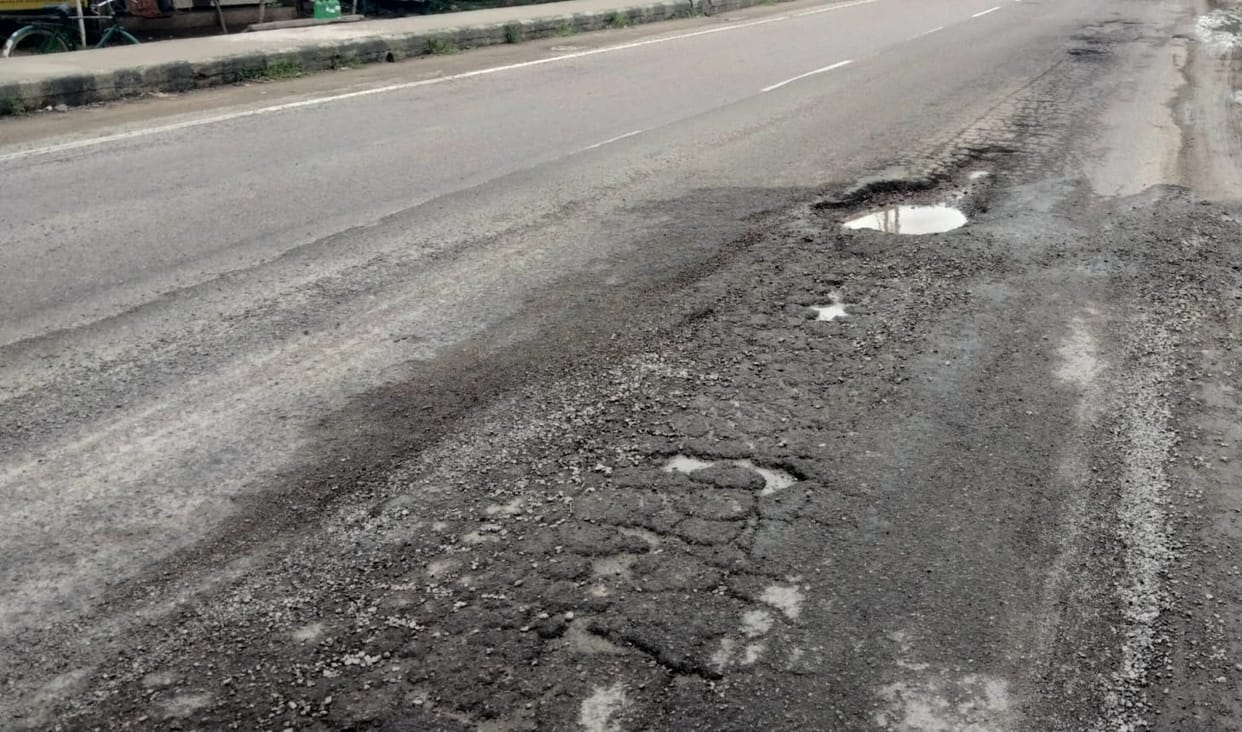 One side of the Yamuna bridge on the highway has caved in due to potholes.