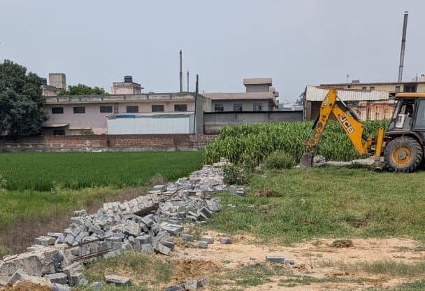 लड़सौली में अवैध चारदीवारी गिराता बुल्डोजर। प्रशासन