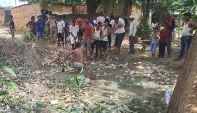 तालाब से वनरोज का शव निकालते ग्रामीण।