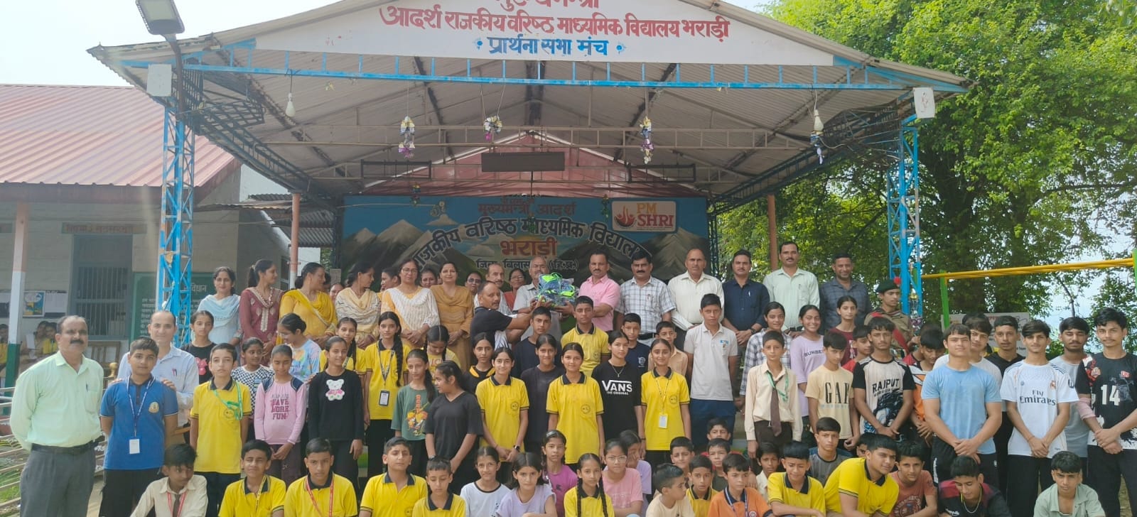 भराड़ी स्कूल में बच्चों को वर्दियां भेंट करते सेवानिवृत्त प्रधानाचार्य। स्रोत: स्कूल प्रबंधन