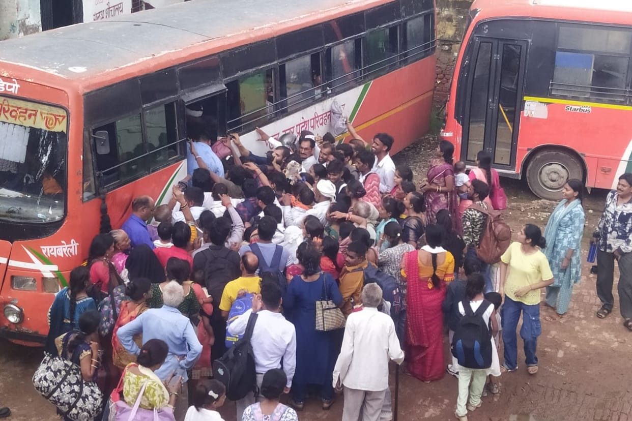 Crowds throng the depot; a scramble to board the buses