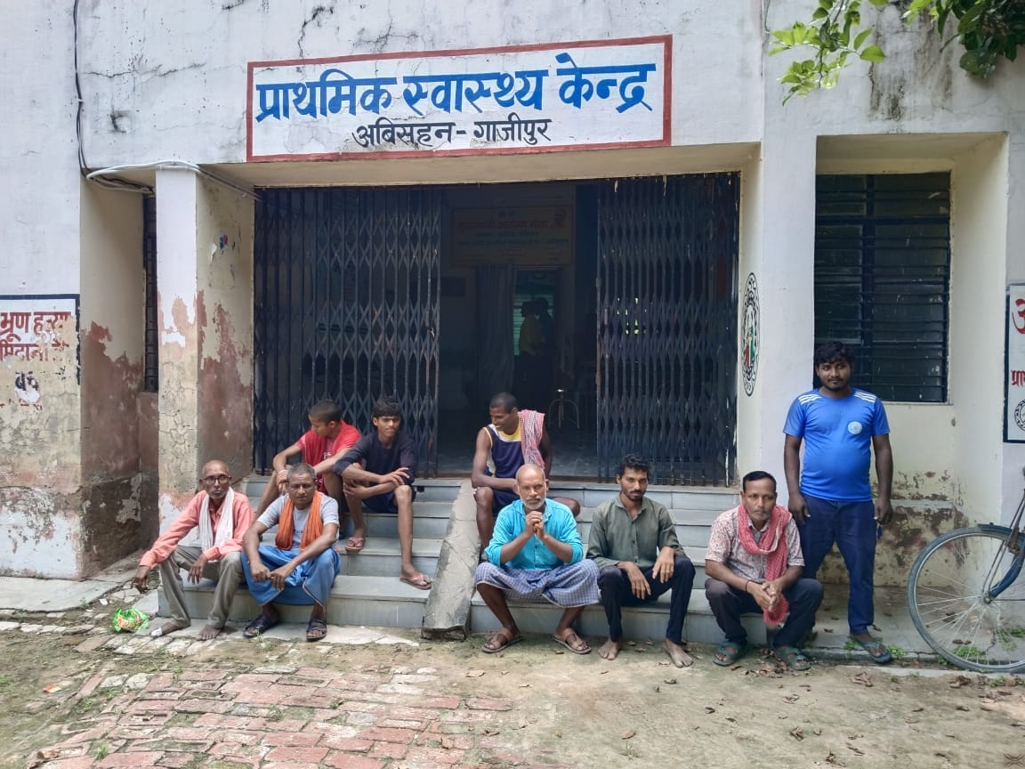 चिकित्सकों के नहीं होने से प्राथमिक स्वास्थ्य केंद्र अविसहन के गेट पर बैठे मरीज व तीमारदार। स्र