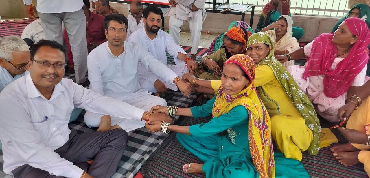 फोटो 28जेएनडी07-रानी तालाब धरनास्थल पर हड़ताली कर्मचारियों को राखी बांधती महिला कर्मचारी। स्रोत