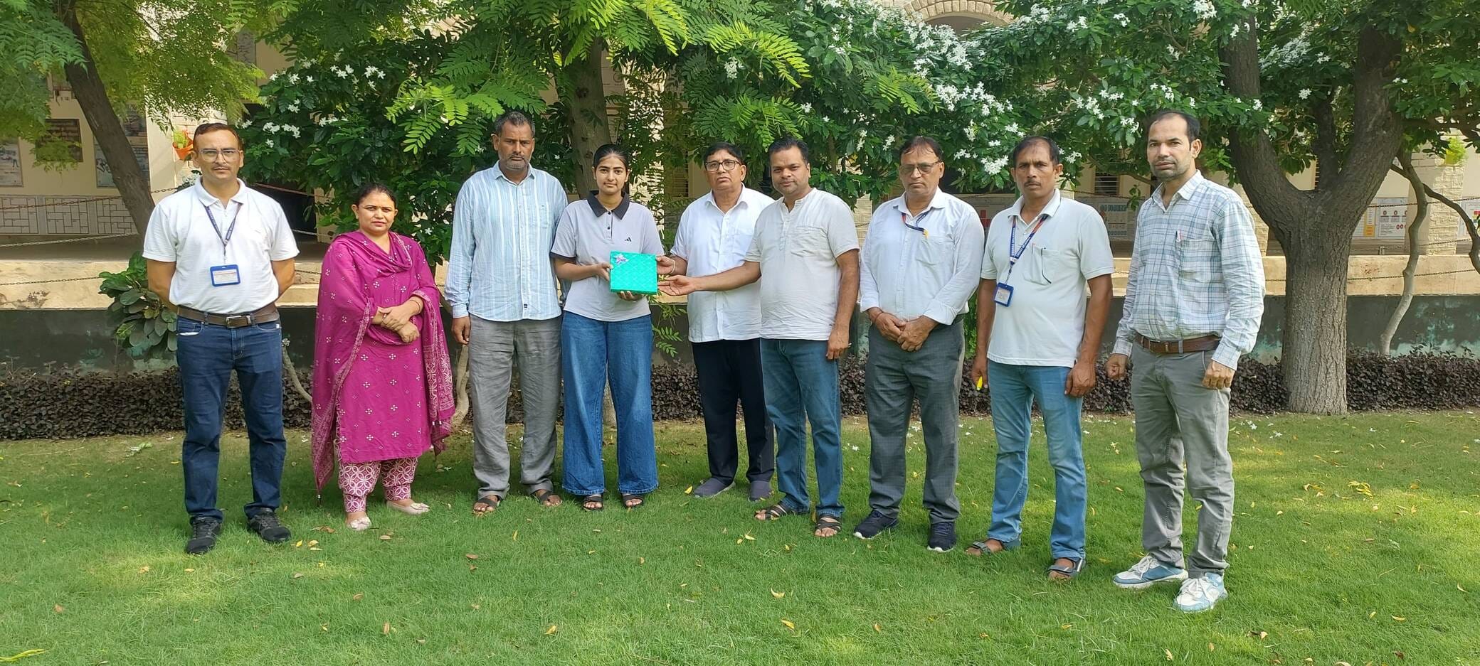 फोटो 6 नरवाना। छात्रा मुस्कान को सम्मानित करते हुए विद्यालय स्टाफ सदस्य। स्रोत संस्थान।