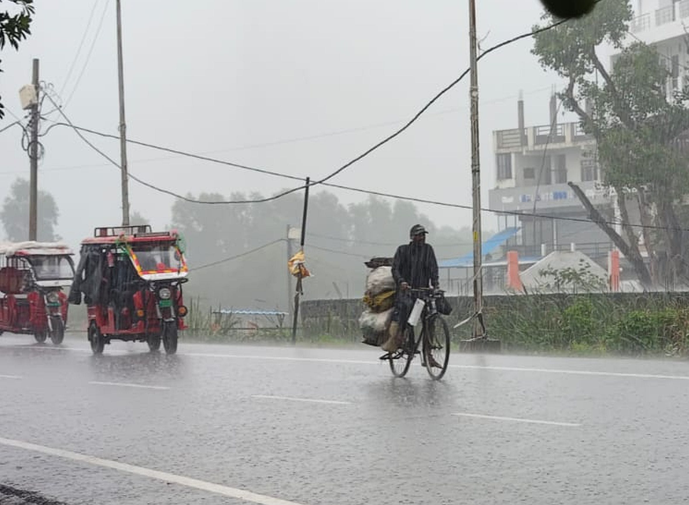 . गौरीगंज में हो रही बारिश के बीच गुजरते राहगीर। -संवाद  