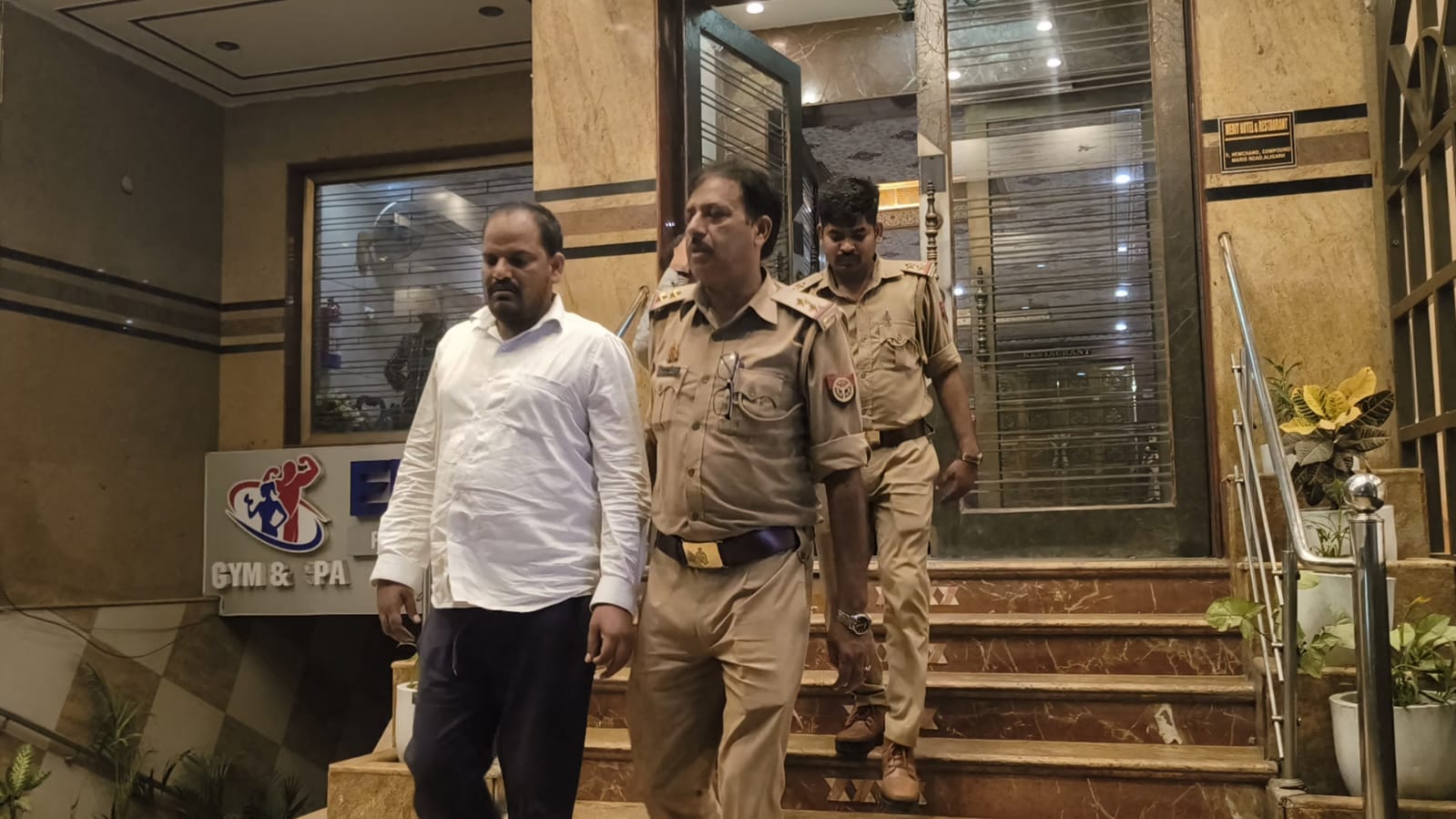 होटल से पकड़ कर आरोपियों को ले  जाती पुलिस। स्रोत  : वीडियोग्रैब