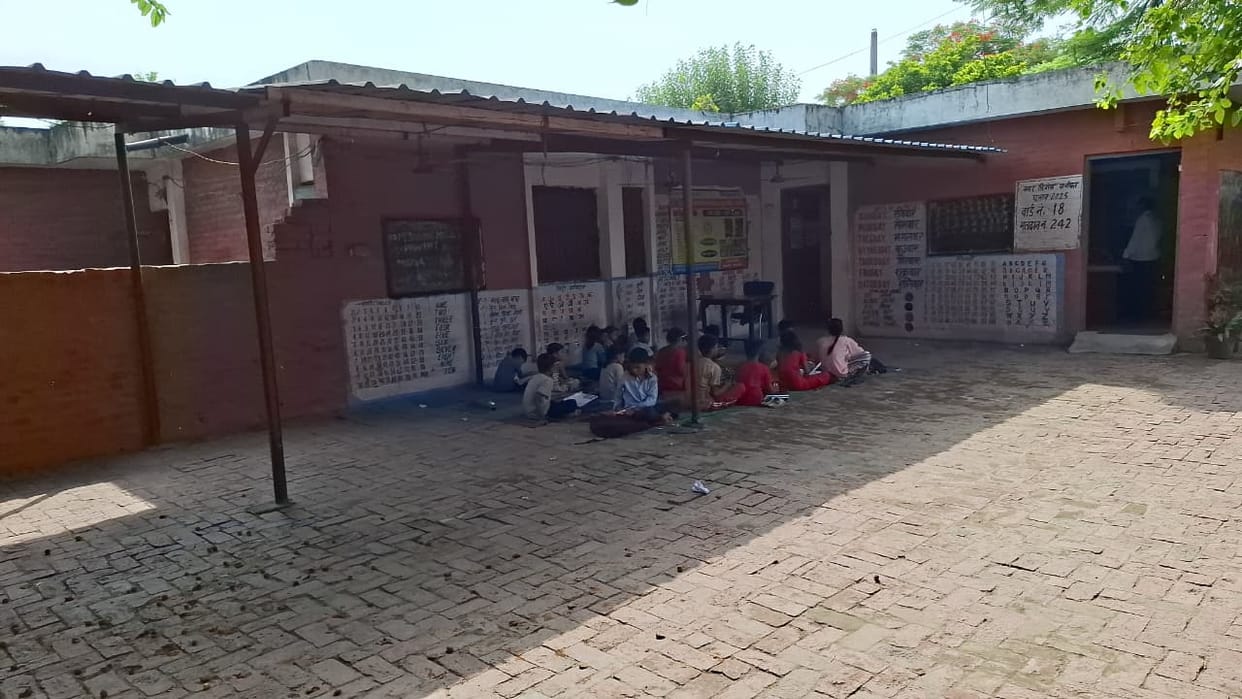 Three schools operating in the same building; classes being held in the park's hall.