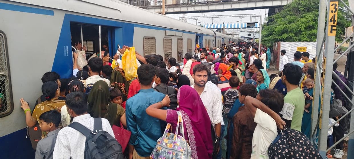 Passengers forced to travel hanging from the train.
