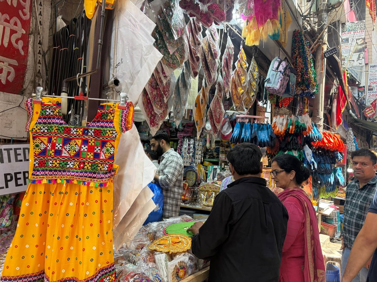 Children are selecting costumes such as those of Radha-Krishna, Sudama, Kansa, and Balarama.