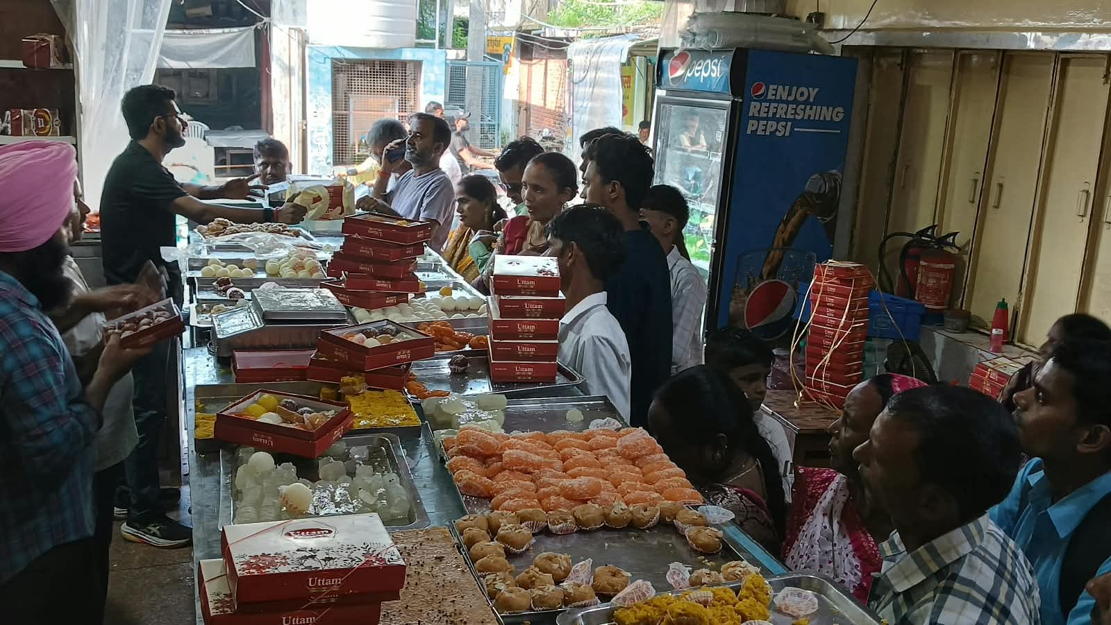 शहर के एक मिष्ठान भंडार से मिठाइयां खरीदते ग्राहक। संवाद 