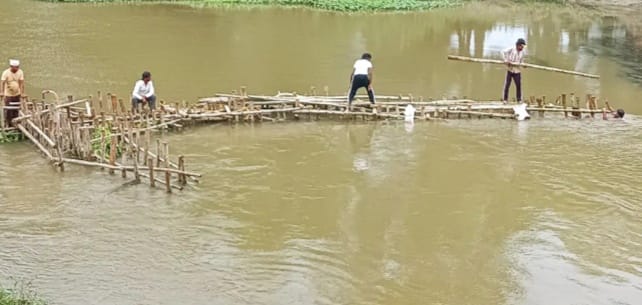 Work begins on constructing a wall of wooden poles at Bhakra Dam.