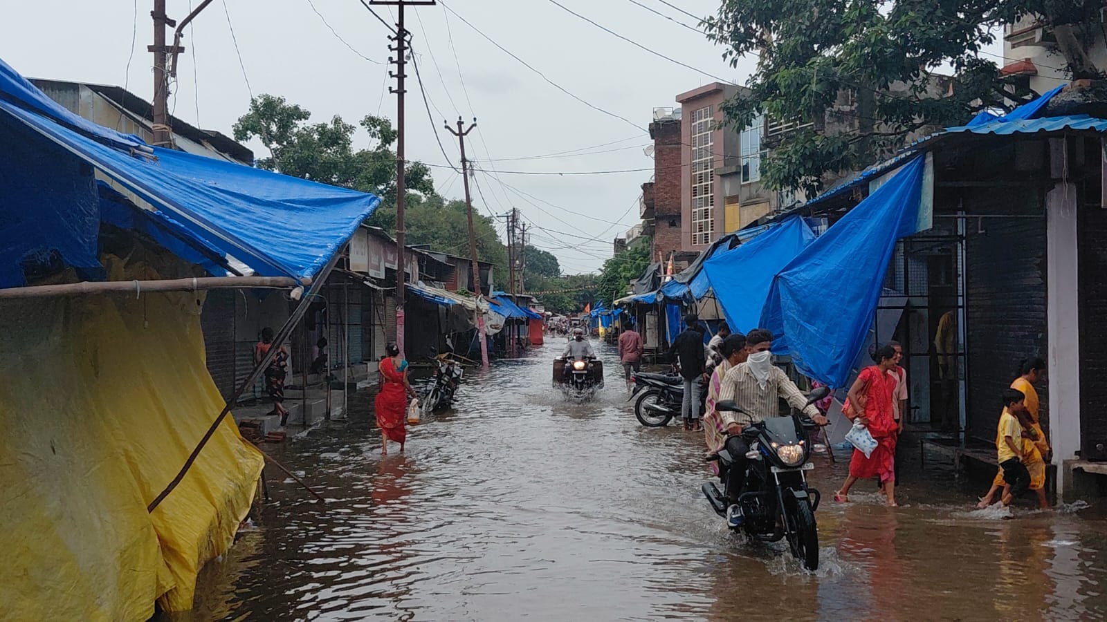 गोला के मिल डायवर्जन मार्ग पर जल भराव से निकलती महिलाएं। संवाद