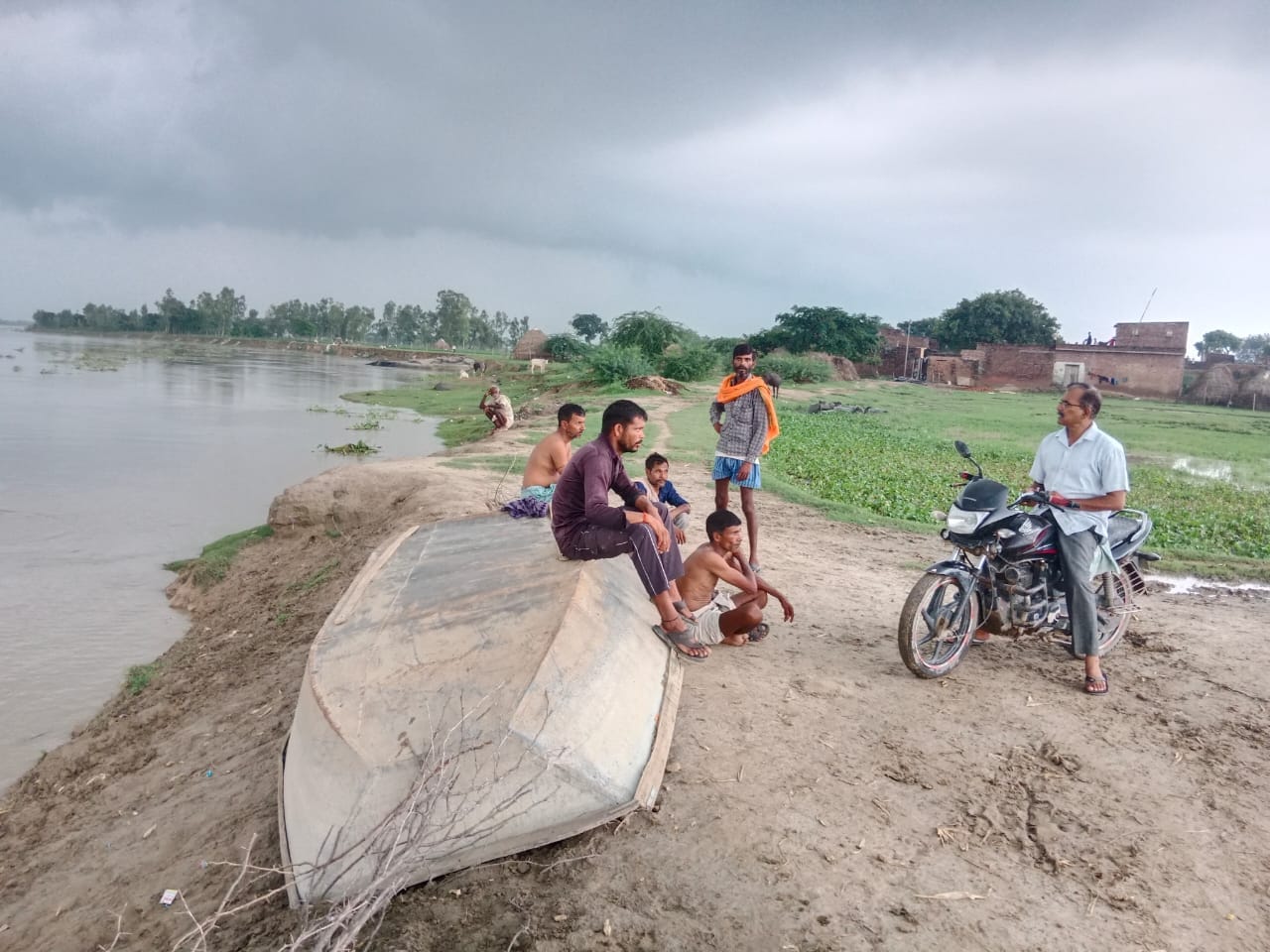 परौर में नदी का बढ़ता जलस्तर देखते लोग। संवाद