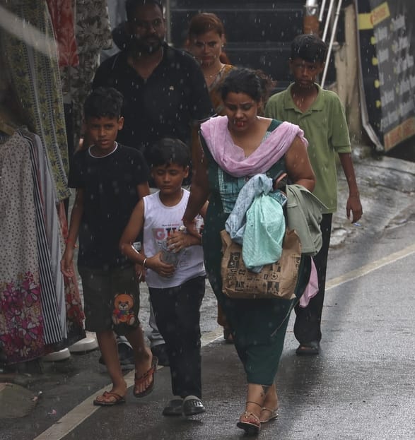 धर्मशाला में दोपहर बाद शुरू हुई बारिश के बीच सुरक्षित स्थान की ओर जाते हुए पर्यटक।  अमर उजाला