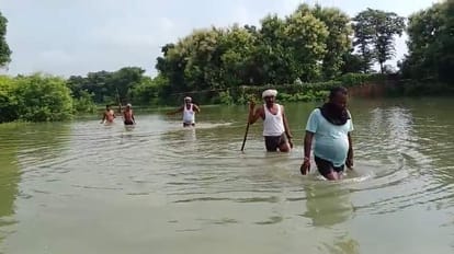 चंदौली में डूबी फसल को देखते किसान। संवाद