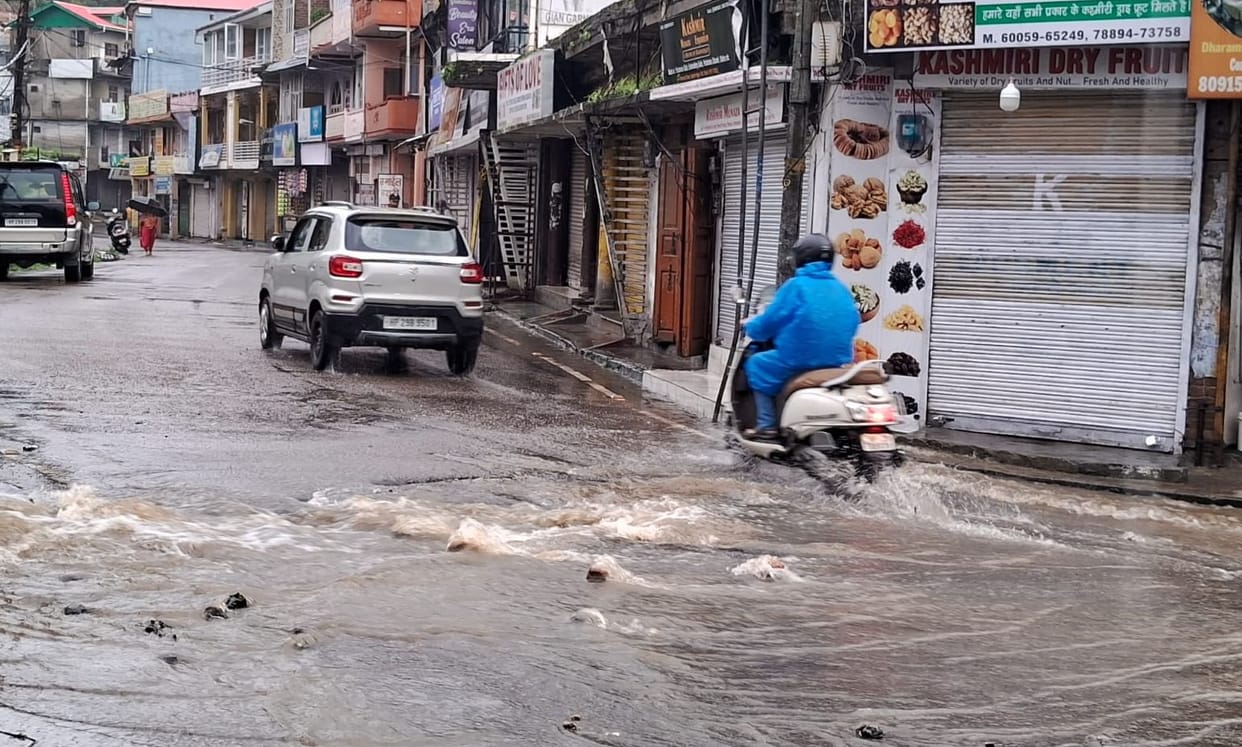 Rain turns roads into ponds; water enters homes and shops.