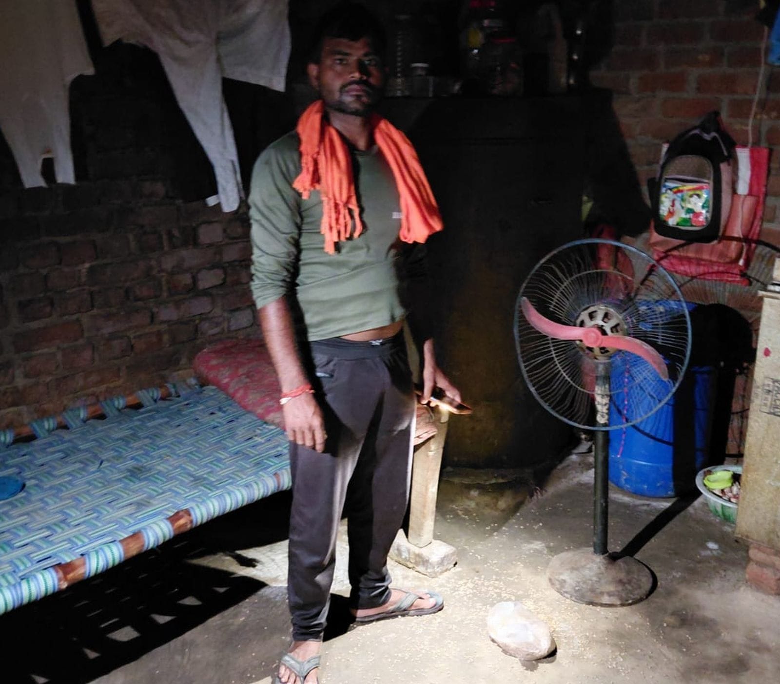 कमरे में घटना की जानकारी देते आयुष के चाचा, पास ही रखा फर्राटा पंखा और पीछे रखी कुठिया। संवाद