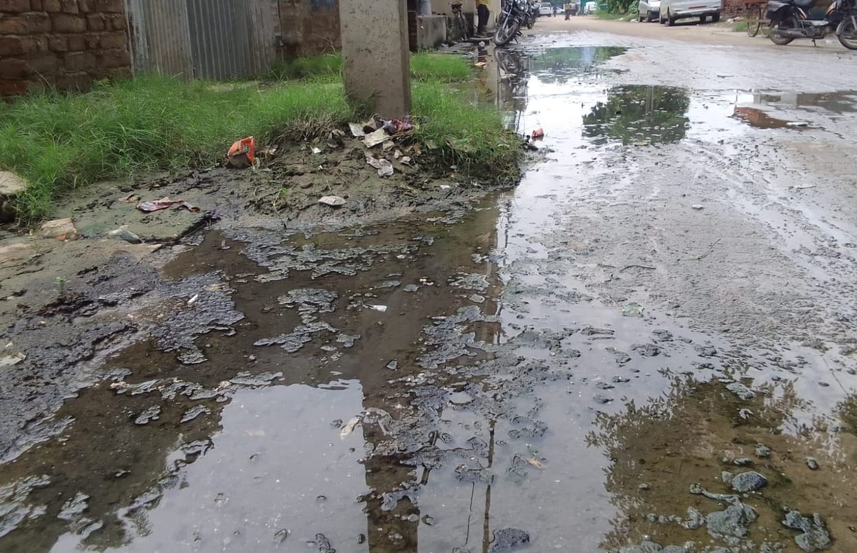 Filthy water flowing onto the road due to drain overflow.