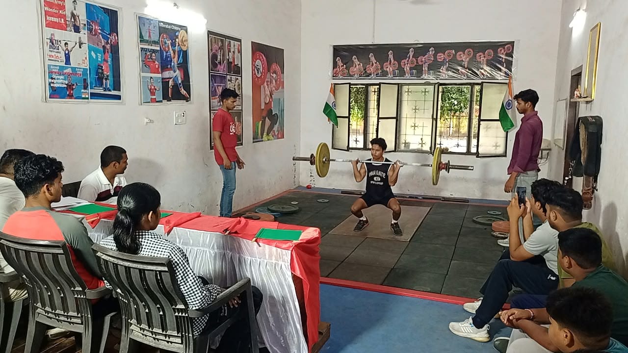 वेटलिफ्टिंग प्रतियोगिता में भार उठाता खिलाड़ी।