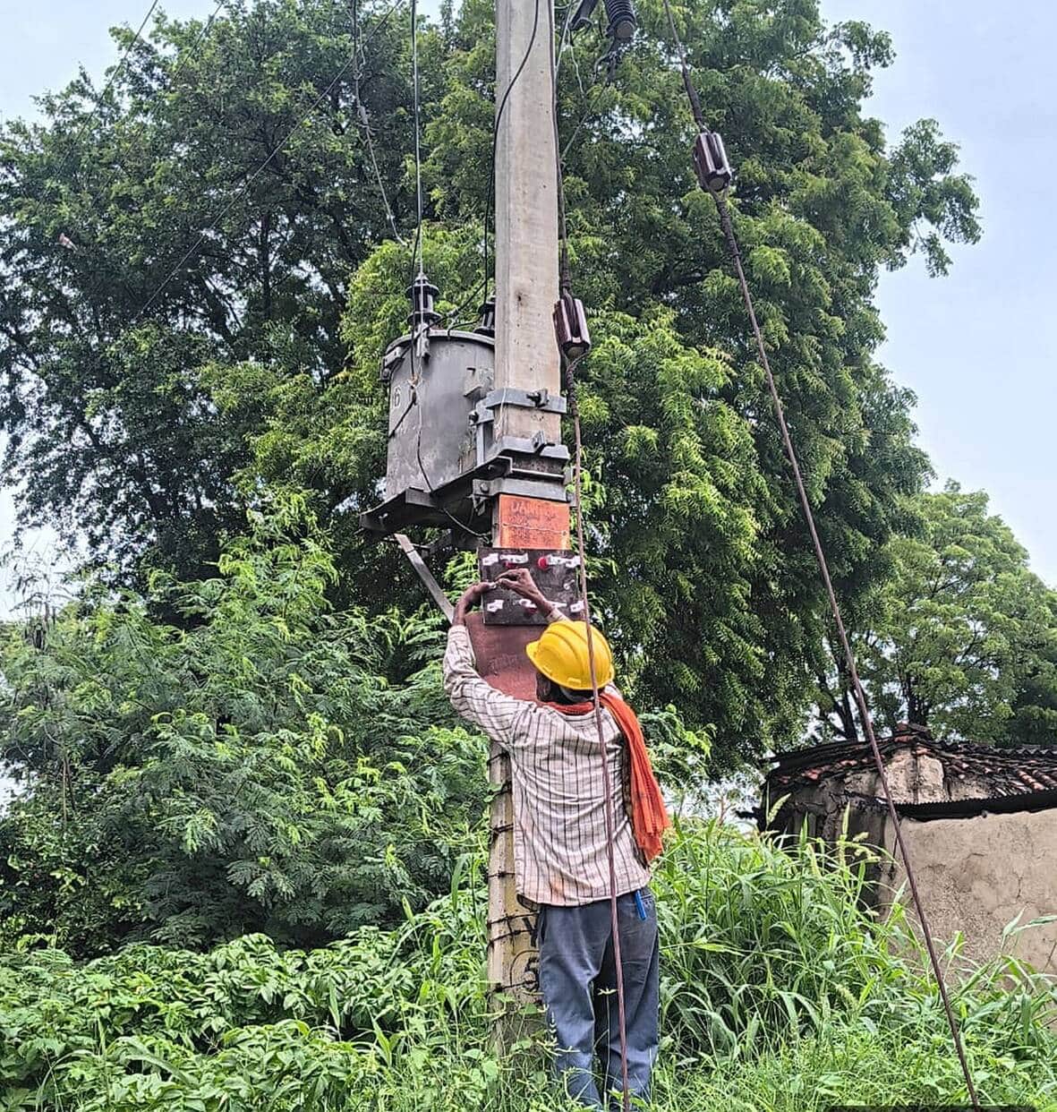 अमेठी के सीतारामपुर गांव में लोकल फॉल्ट की मरम्मत करता ऊर्जा निगम कर्मी।-संवाद