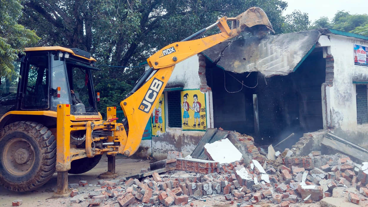 Bulldozer razes dilapidated school building; demand raised for a boundary wall.