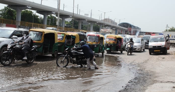 फरीदाबाद सेक्टर 20 बी में राष्ट्रीय राजमार्ग के सर्विस रोड पर भरा बारिश का पानी व टूटी सड़क के 