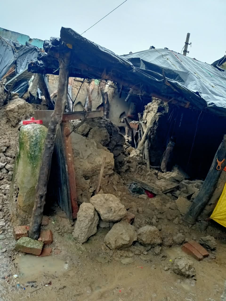 Elderly man dies after being buried under debris when an unbaked-brick wall collapses in the rain.
