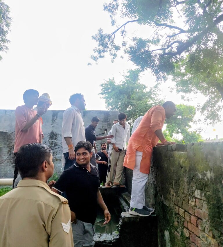 दीवार फांदकर विद्यालय में घुसते राज्यमंत्री।