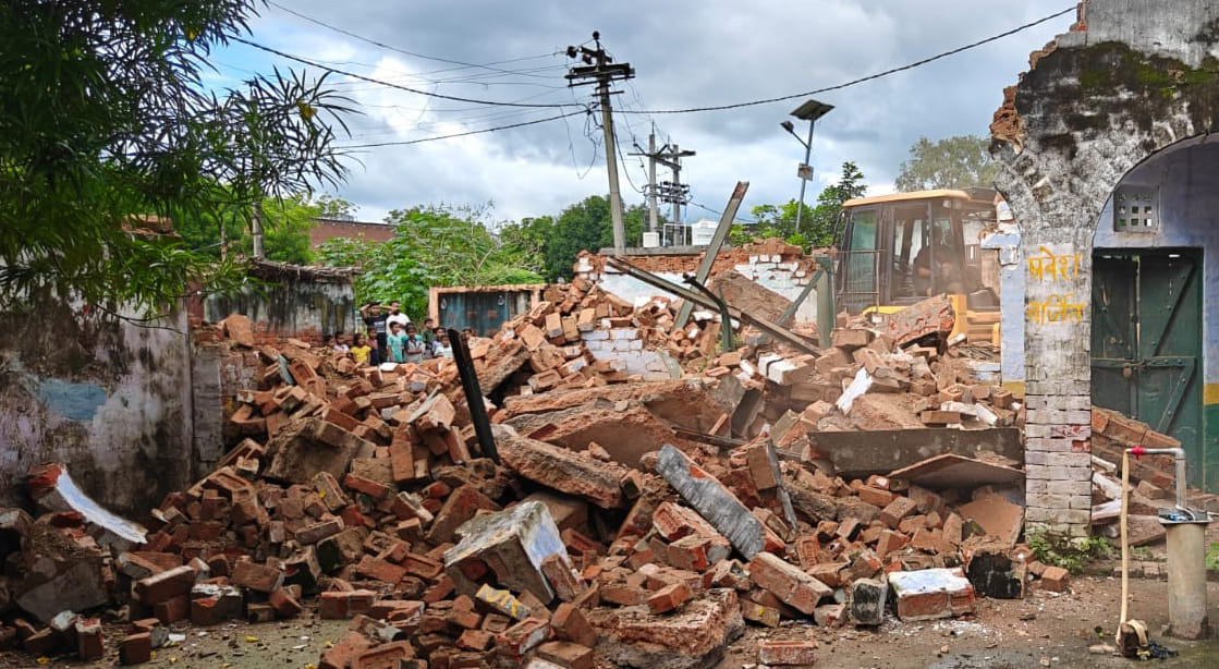 Bulldozer razes dilapidated school building.