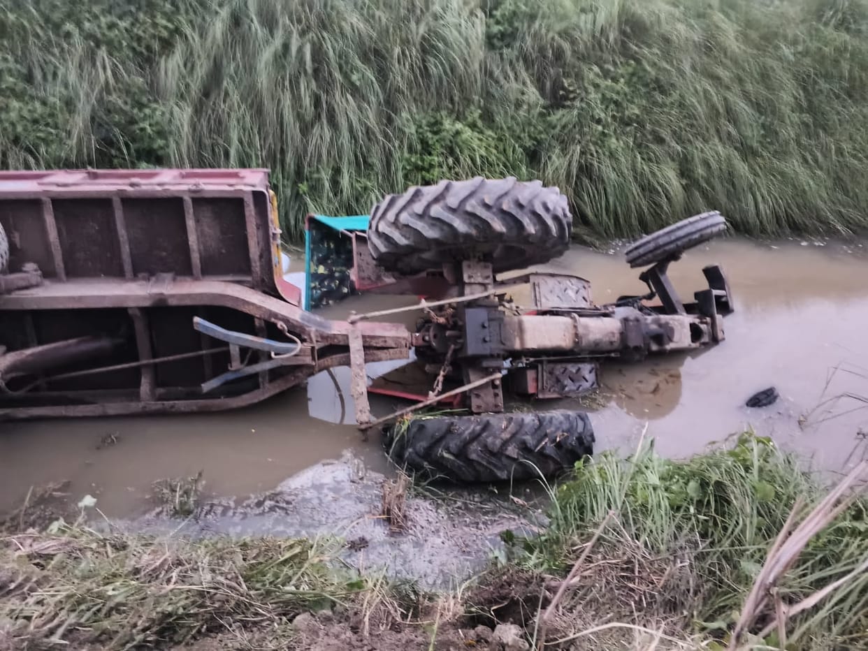 Tractor stuck in marsh overturns into canal; driver injured.