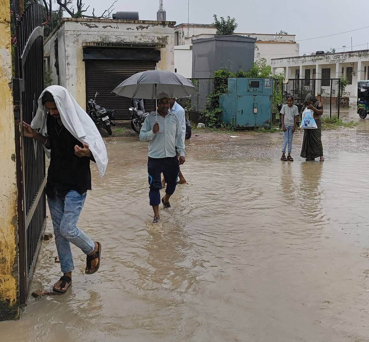 . जिला अस्पताल के मेन गेट पर हुए जलभराव के बीच से गुजरते राहगीर। -संवाद