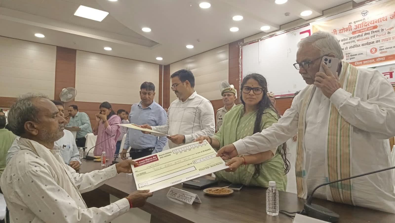 जिला पंचायत सभागार में आउटसोर्स कर्मियों को मानदेय वृद्धि का डेमो चेक देतीं डीएम प्रियंका निरंज