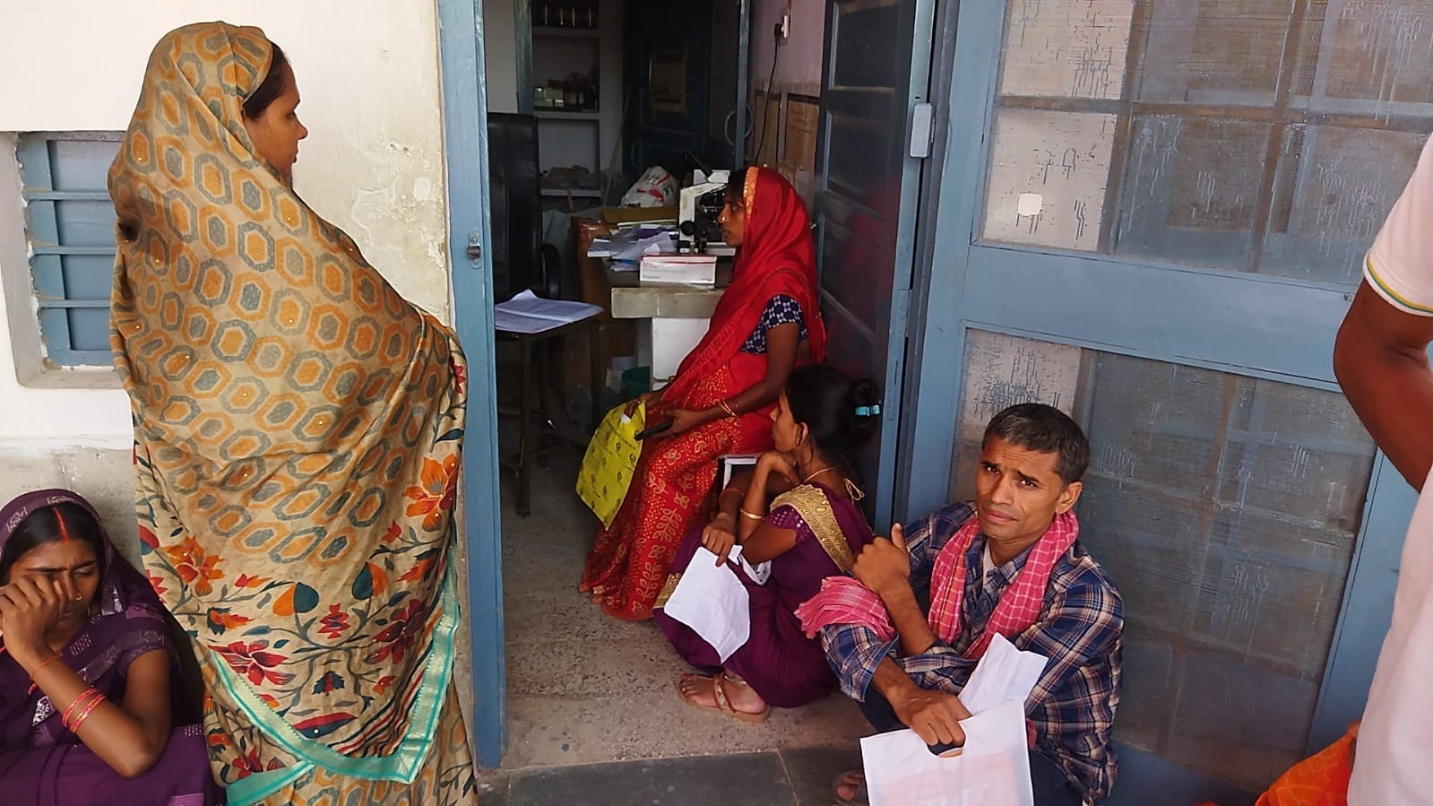 सामुदायिक स्वास्थ्य केंद्र सोनबरसा में उपचार कराने के लिए अपने नंबर आने का इंतजार करते मरीज और 