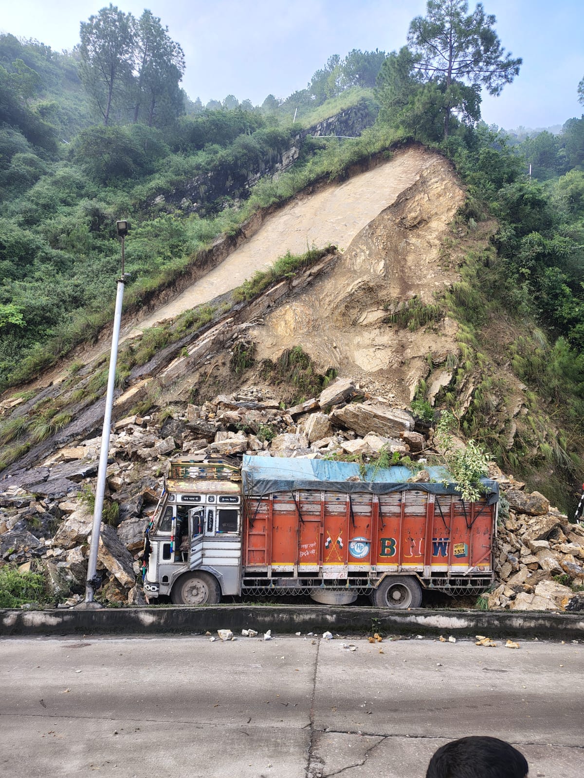 Truck damaged by falling debris amidst heavy rain; major accident averted.