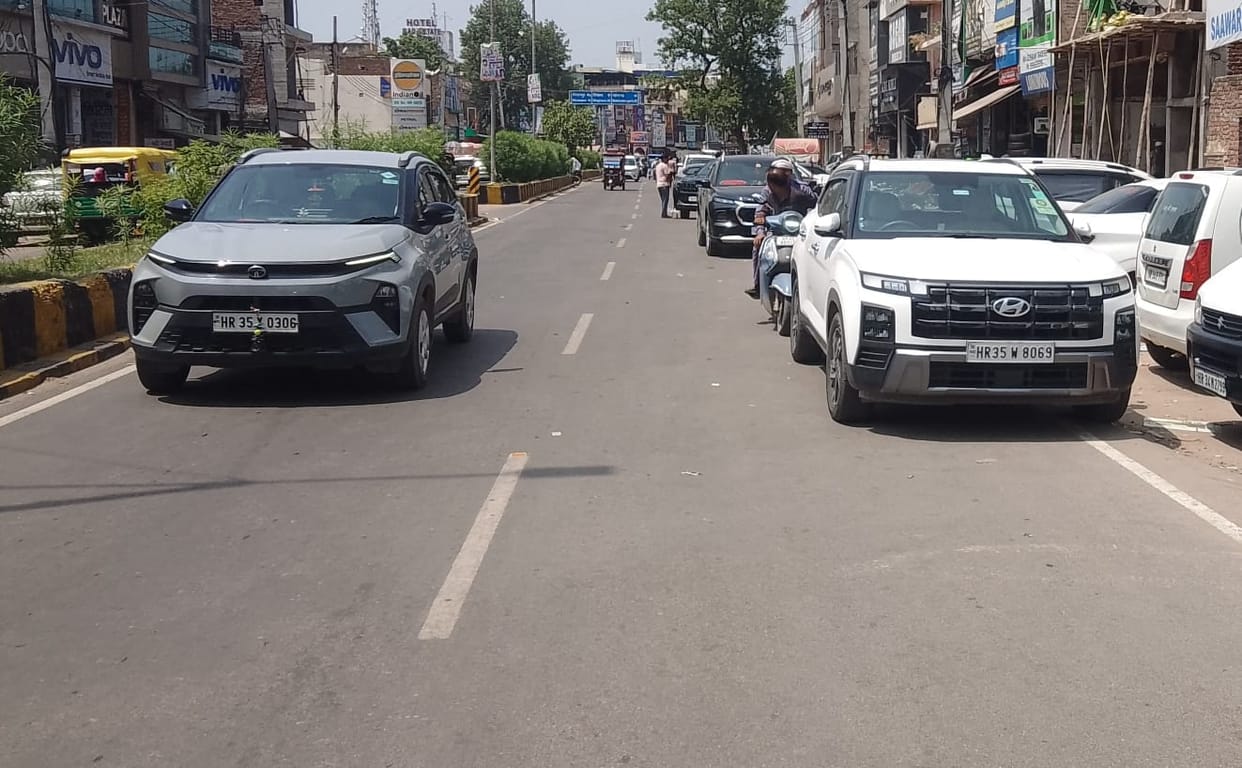 Vehicles parked on the road caused traffic jams the foot wide road was reduced to feet
