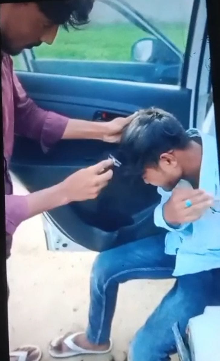 पिटाई के बाद युवक के बाल मुंडवाए। स्रोत: वीडियोग्रैब