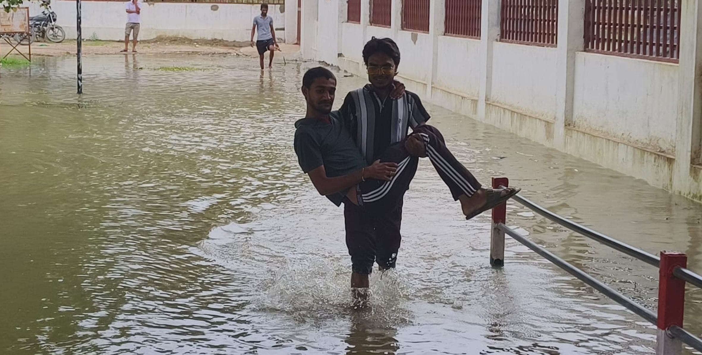 रायबरेली में शहीद स्मारक परिसर में सई के पहुंचे पानी से होकर इस तरह निकलते लोग।